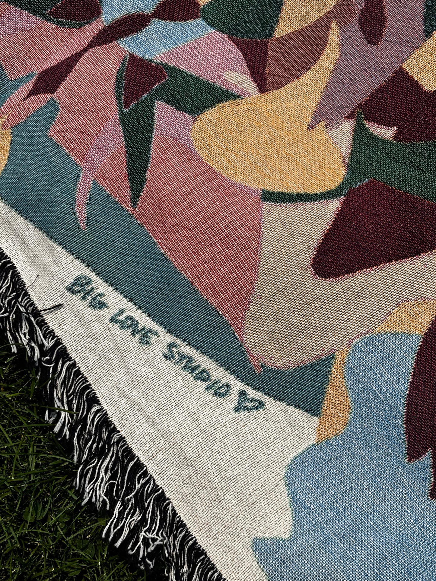 A close up of woven texture and edge fringe of the blanket.